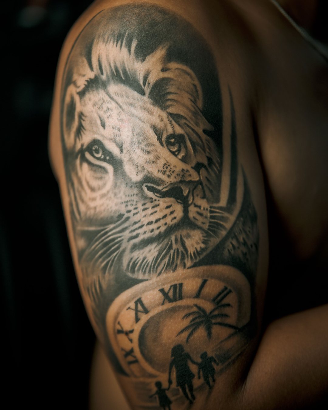 León y reloj en realismo black y grey en el hombro