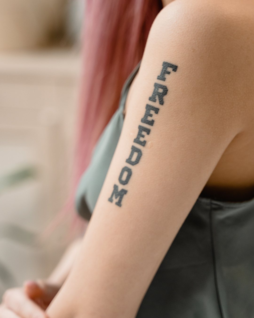 Palabra Freedom en lettering a lo largo del brazo
