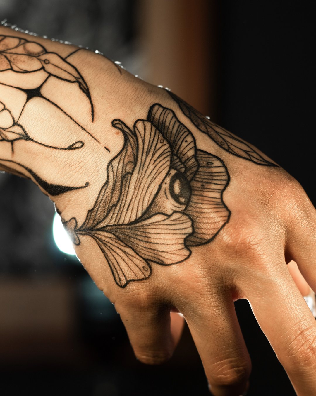 Flor con un ojo en línea negra sobre el dorso de la mano